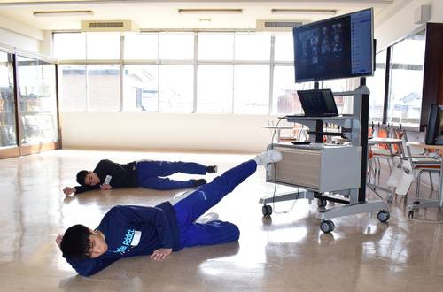 モニター（右）に部員の姿を写し、声を掛け合いながらトレーニングに励む八戸学院光星高男子バスケットボール部員　