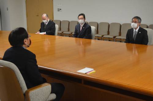 米軍による事故原因調査の結果を三村申吾知事に報告する熊谷昌司局長（右）＝２２日、青森県庁