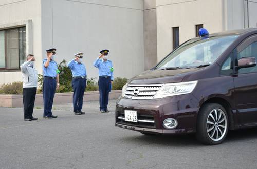 パトロールに出発する車両を敬礼で見送る半澤一人署長（左から２人目）
