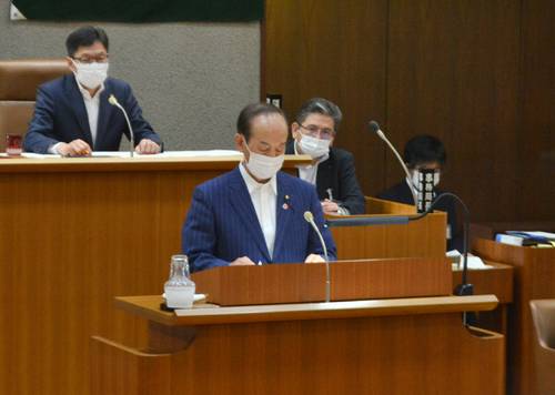 米軍三沢基地内で感染者が確認された問題を受け、三沢市の対応について答弁する小桧山吉紀市長（手前）＝１８日、市議会議場