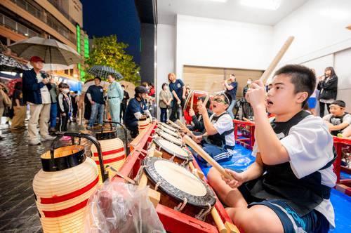 八戸市中心街でお囃子を披露する六日町附祭若者連のメンバー。今年の八戸三社大祭は山車運行が取りやめとなったが、祭り囃子は夏夜に響き渡っている＝１日午後７時３５分ごろ