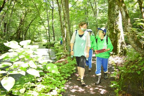 雑談を交えながら、奥入瀬渓流を英語でガイドする生徒（右）