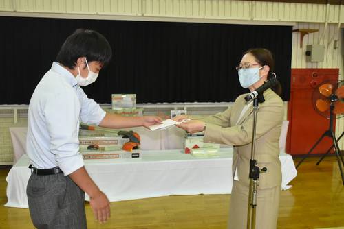 生徒代表に目録を手渡す佐々木千佳子社長（右）