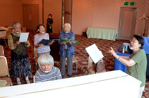 木村かほるさんの出迎えの日に披露する校歌の練習に励む、高校の同期生たち＝９月中旬、八戸市