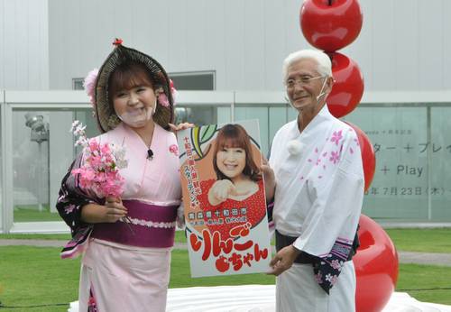 小山田久市長（右）から、拡大版の観光大使の名刺を受け取ったりんごちゃん＝１７日、十和田市