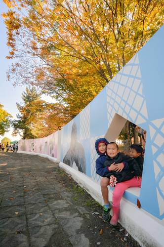 「縄文アート」が描かれた壁面で遊ぶ子どもたち