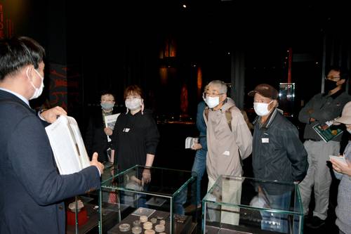 学芸員(左)から土偶などについての説明を受ける来館者