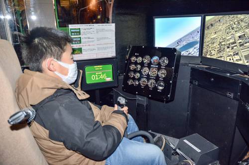 ヘリコプターのフライトシミュレーターを体験する来館者