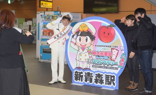 新青森駅の利用者との写真撮影に応じる陣内智則さん(左)=13日、青森市