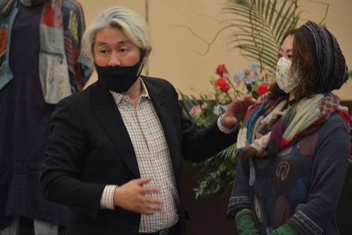 ストールの巻き方をアドバイスする佐藤正樹さん（左）