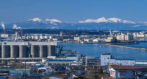 冬晴れとなった八戸市内。八戸港越しに冬化粧した八甲田連峰がくっきりと浮かび上がった＝２５日午前１１時５０分ごろ、同市鮫町