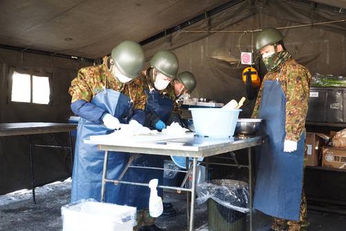 野外炊具を用いて調理をする隊員